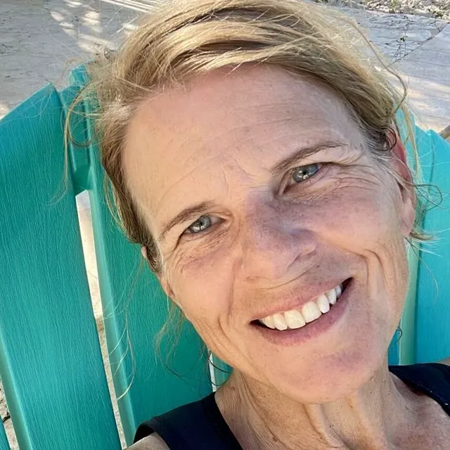 Shawn Sutherland smiling, sitting in a turquoise beach chair